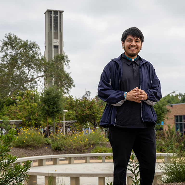 Portrait of transfer student Victor E. Andrade III, B.A.Sociology/Administrative Studies 23’ - he stands in front of the Native American Garden located in the heart of the UC Riverside campus.